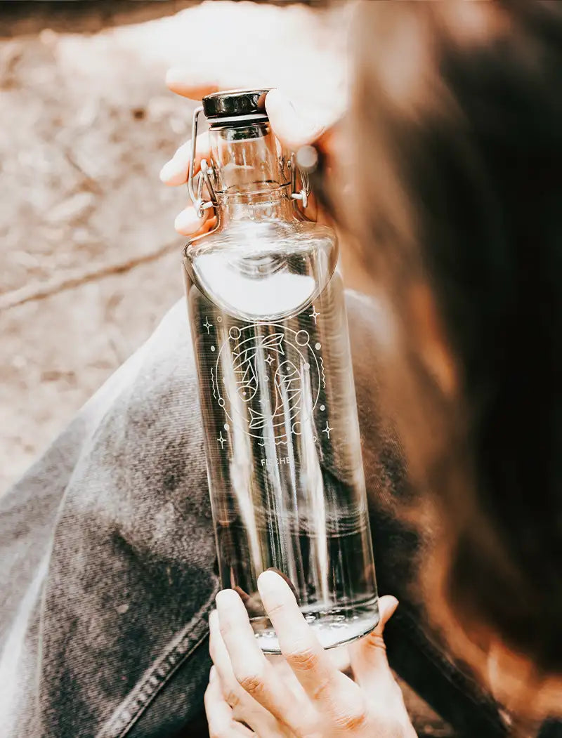 Frau mit Trinkflasche aus Glas mit Gravur Sternzeichen Fische