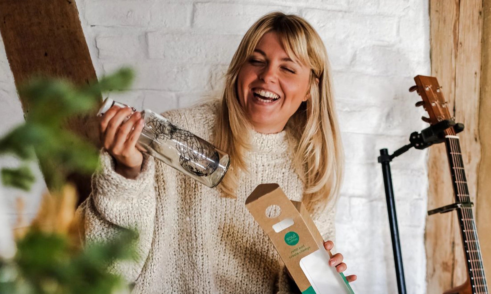 Frau mit Trinkflasche aus Glas in der Hand