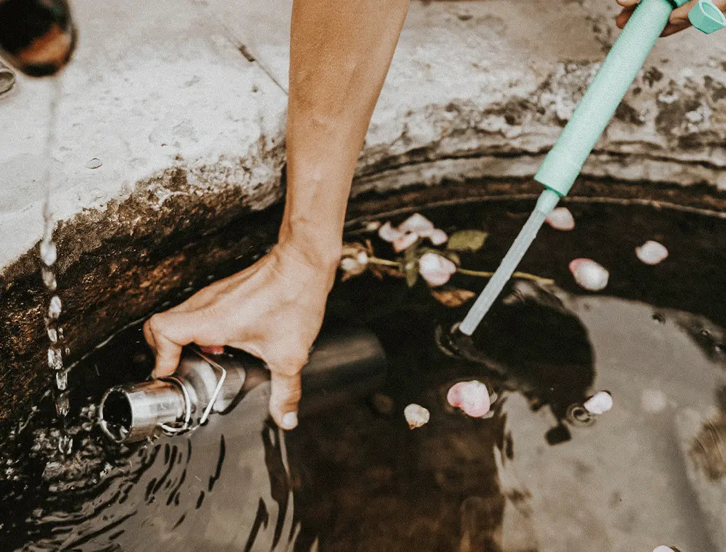 Wasser aus Brunnen in Edelstahlflasche mit Wasserfilter