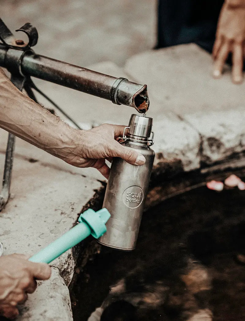 Trinkflasche wird an öffentlichen Brunnen mit Wasser befüllt