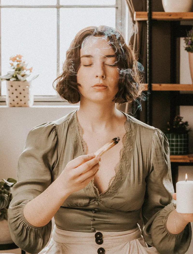 Frau bei Meditation mit Palo Santo