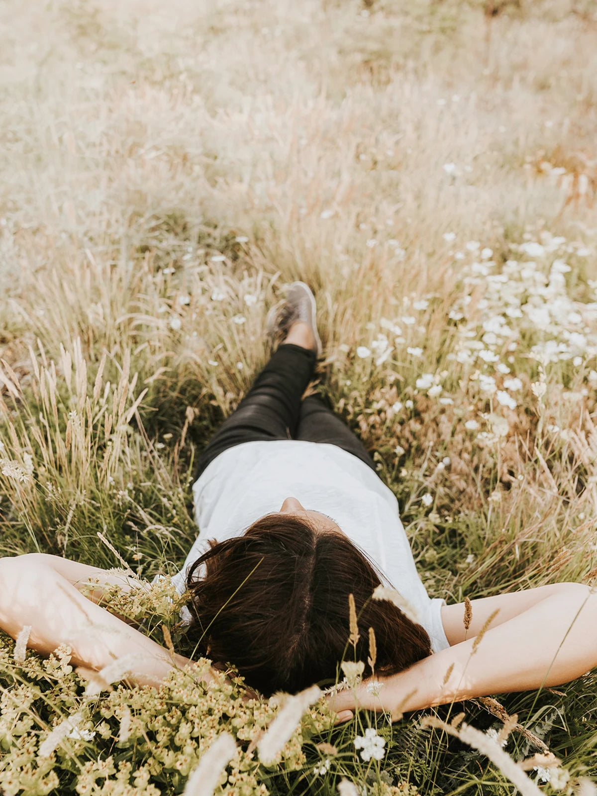 Moodfoto Frau liegt im Sommer auf Wiese