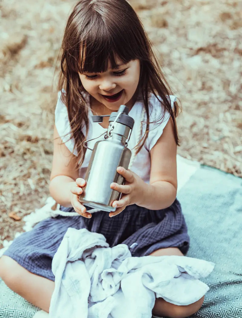 Kind mit leichter kleinen Edelstahltrinkflasche in der Hand