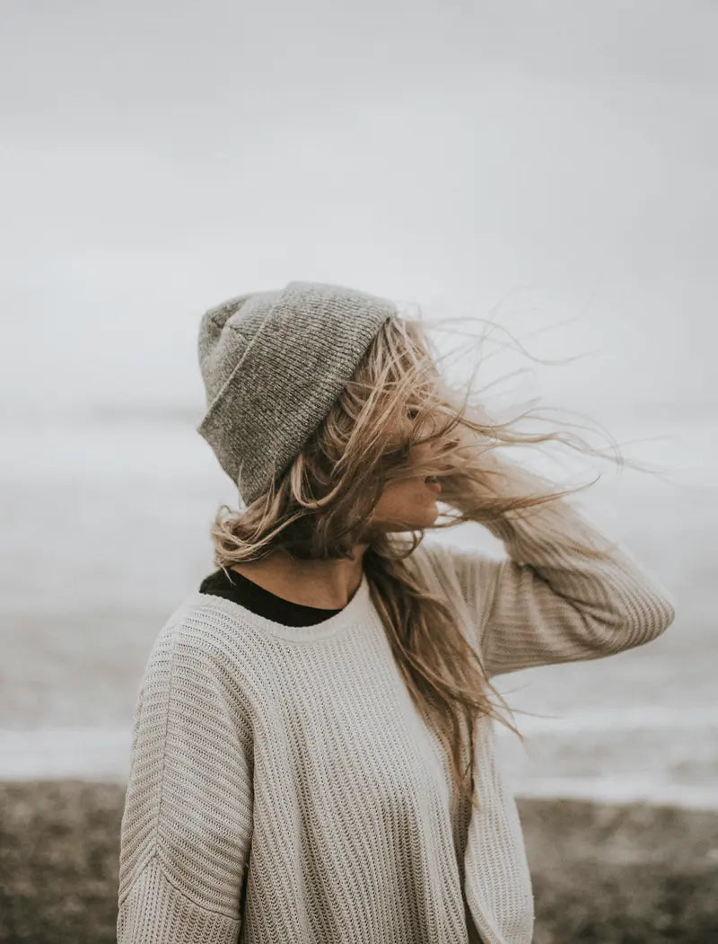 Frau am Strand bei Wind