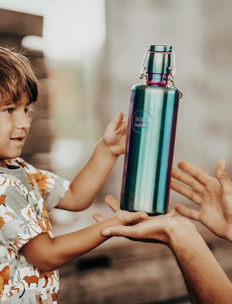 Kind mit Trinkflasche aus Edelstahl im Regenbogenlook