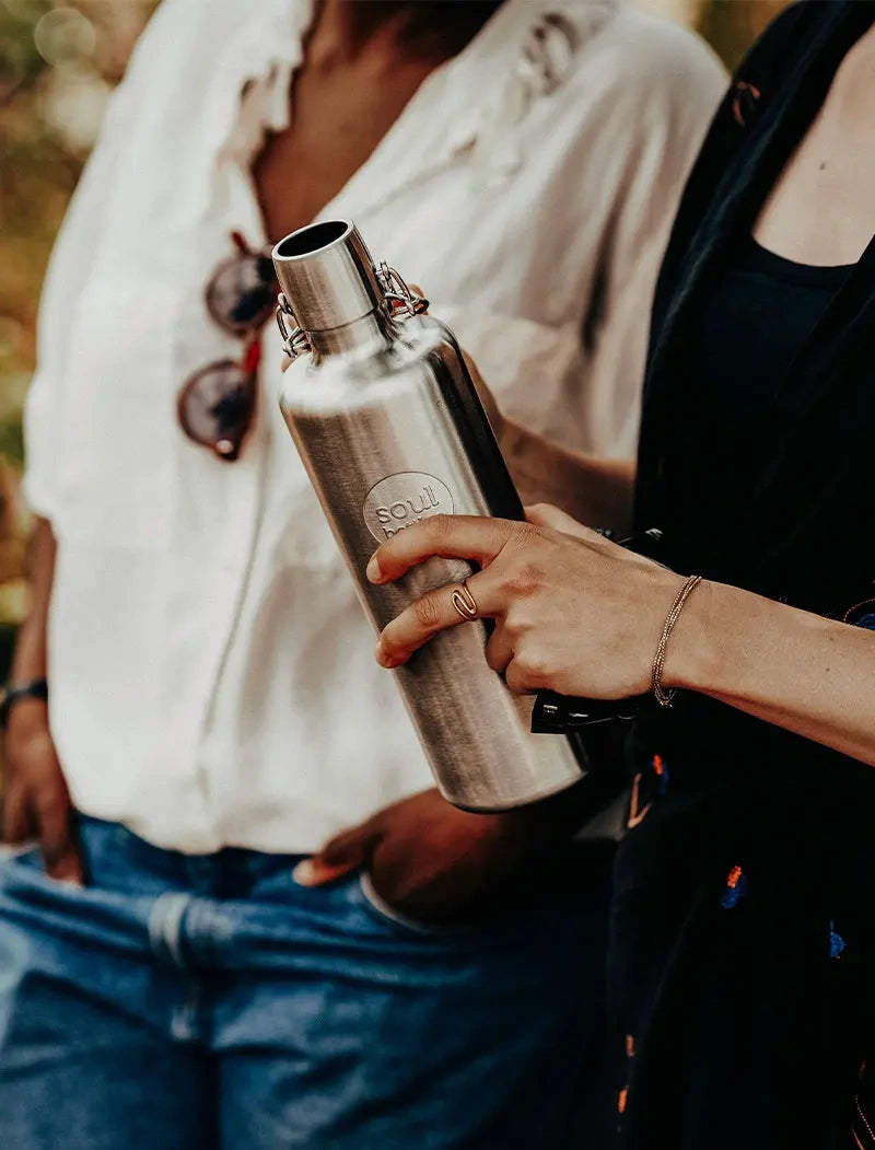 Frau mit Trinkflasche aus Edelstahl in der Hand